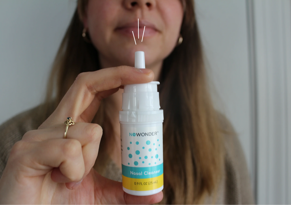 Person holding a bottle of NoWonder nasal cleaner 