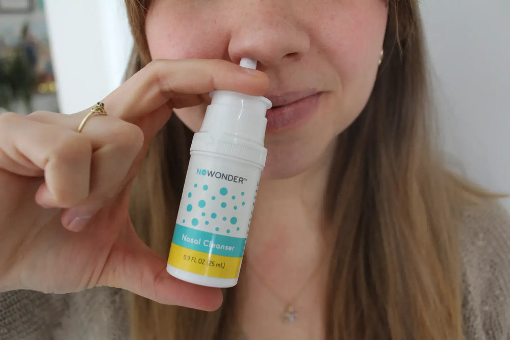 Person using a NoWonder nasal cleanser spray.